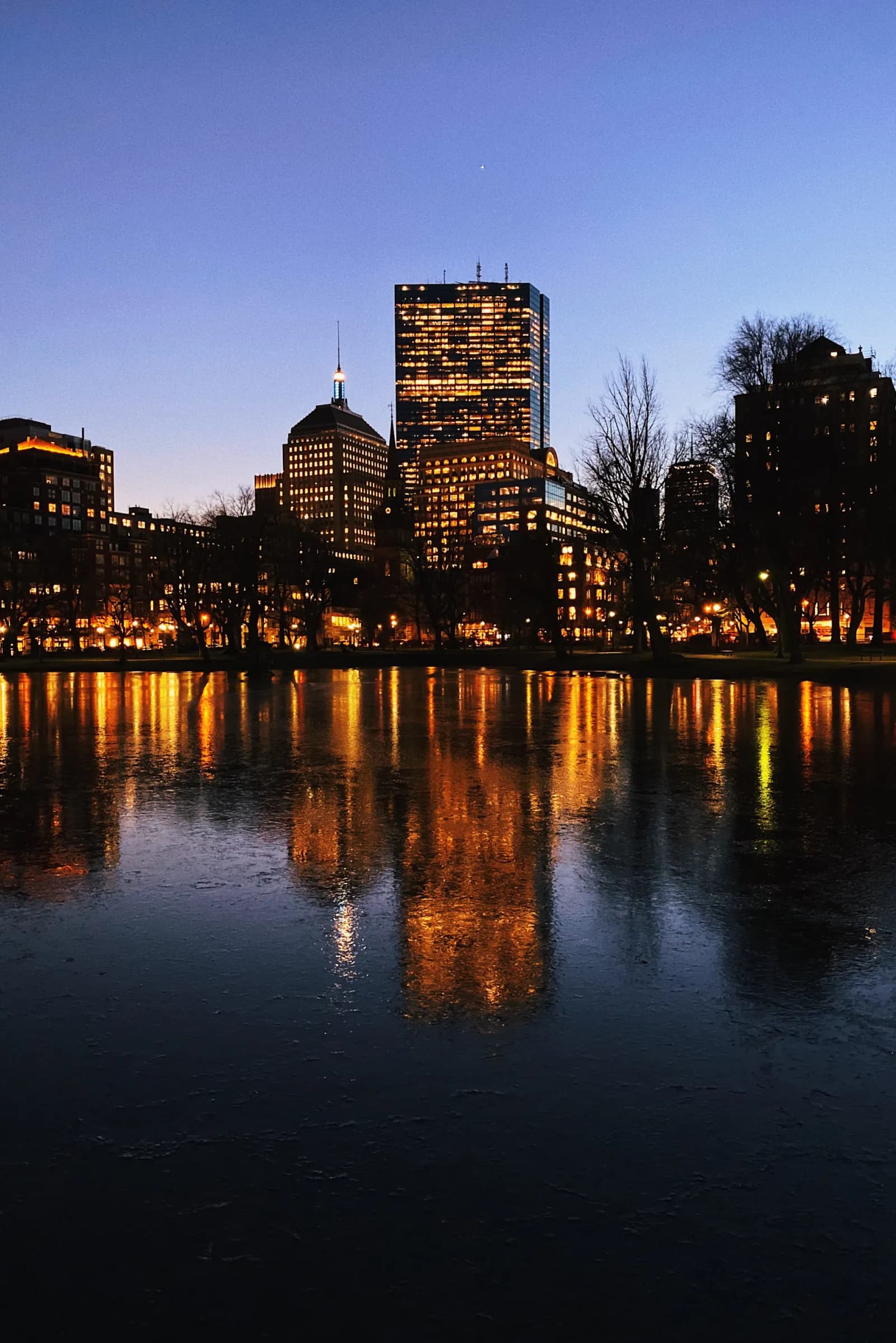 Boston skyline reflected in the water at dusk