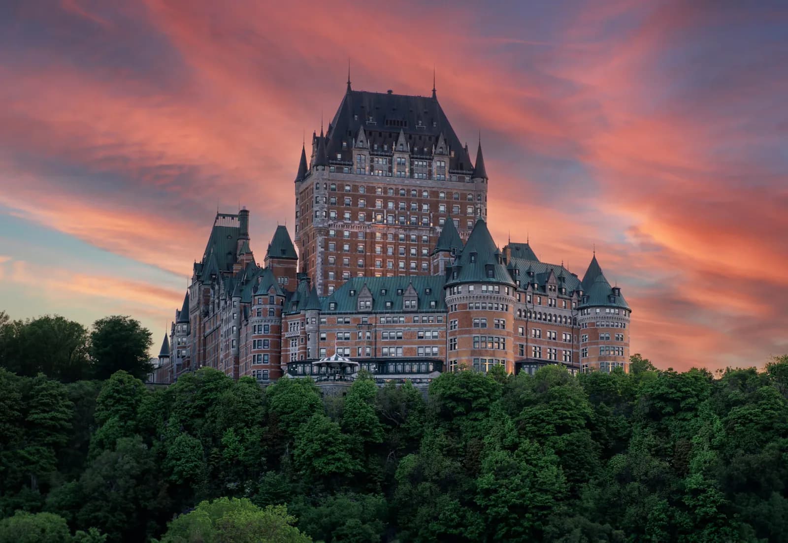 Le Château Frontenac au-dessus de Québec sous un coucher de soleil rose