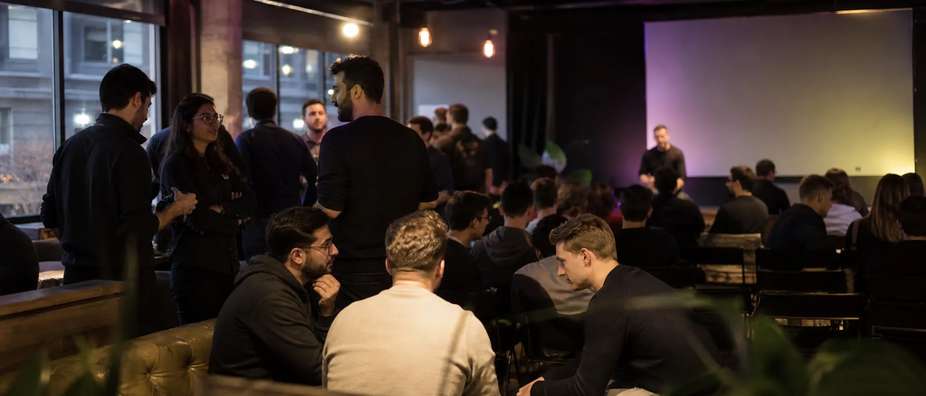 A full room at a Spark night, with a presenter on stage